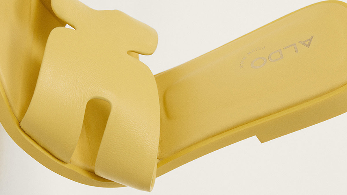 Yellow slide sandal with 'ALDO' branding on a light background