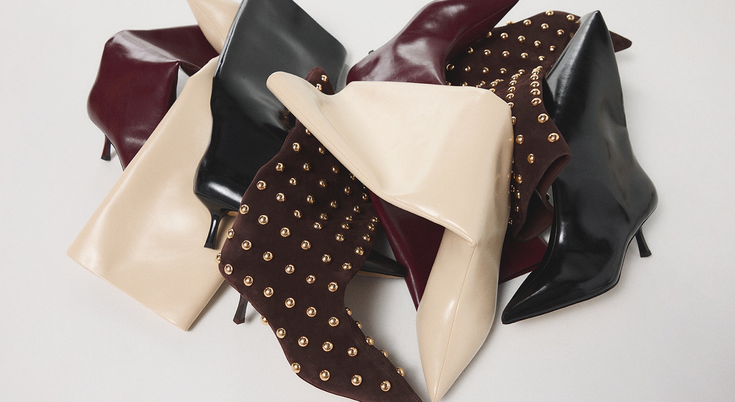 Collection of women's high-heeled shoes in various colors and styles on a light background.