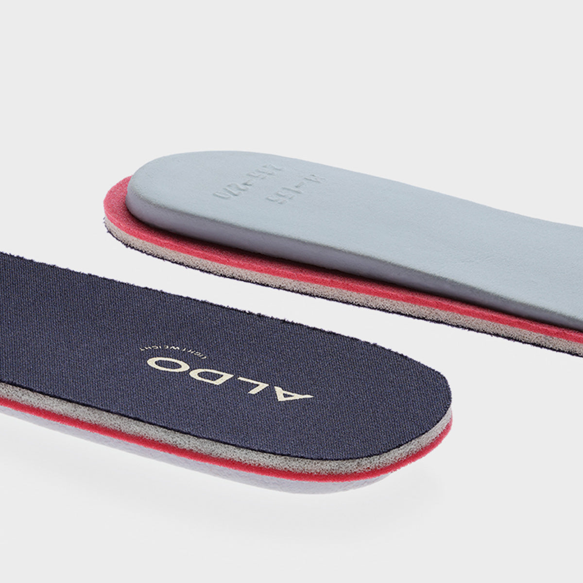 Two pairs of insoles, one gray and one navy with red accents, on a light gray background.