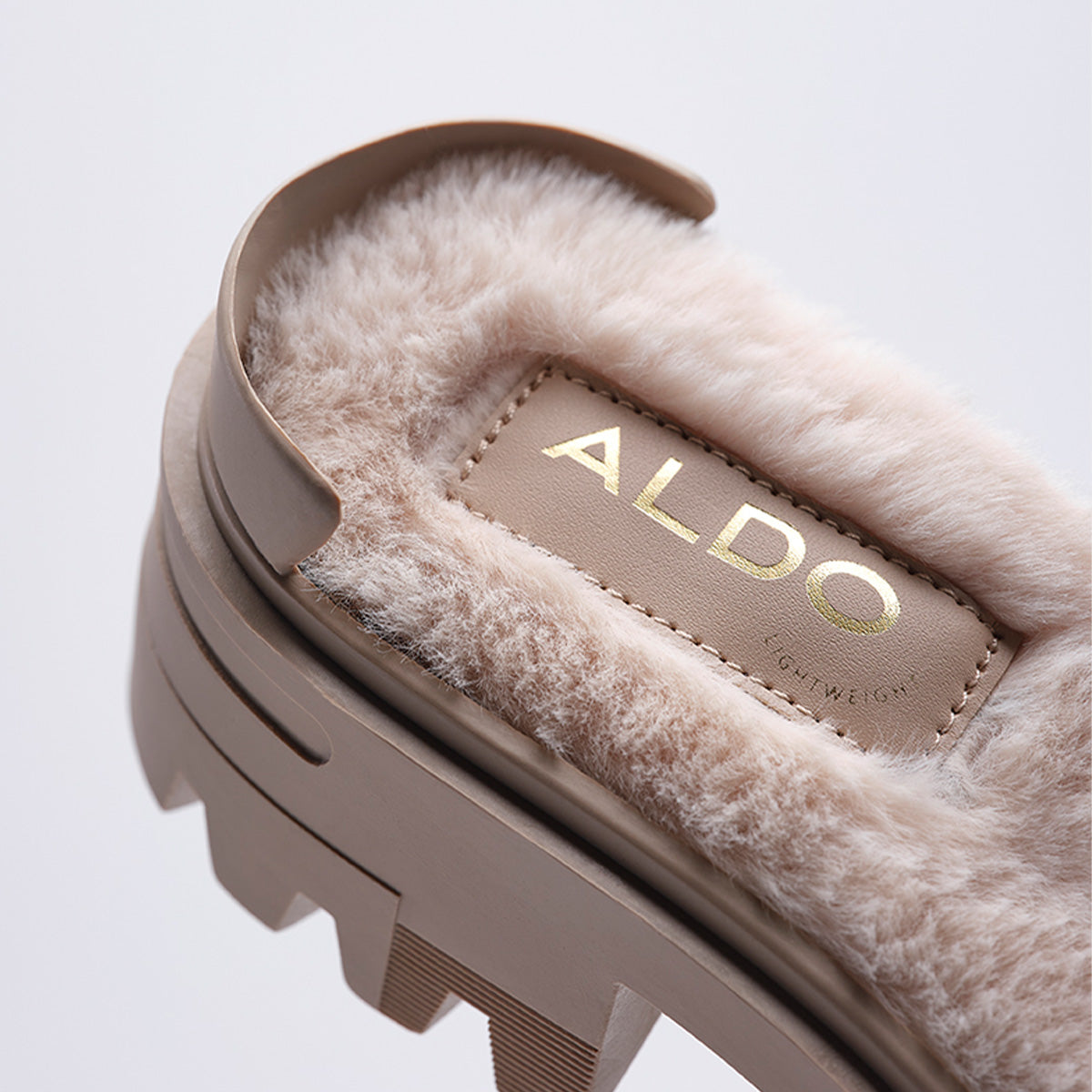 Close-up of a fluffy sandal with 'ALDO' branding on a light gray background