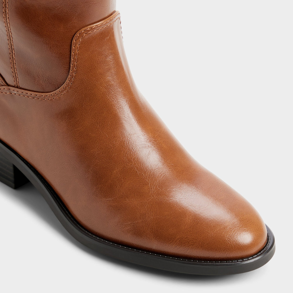 Three-quarter angle of Tan Kaydienh Block heel knee-high boot's front side